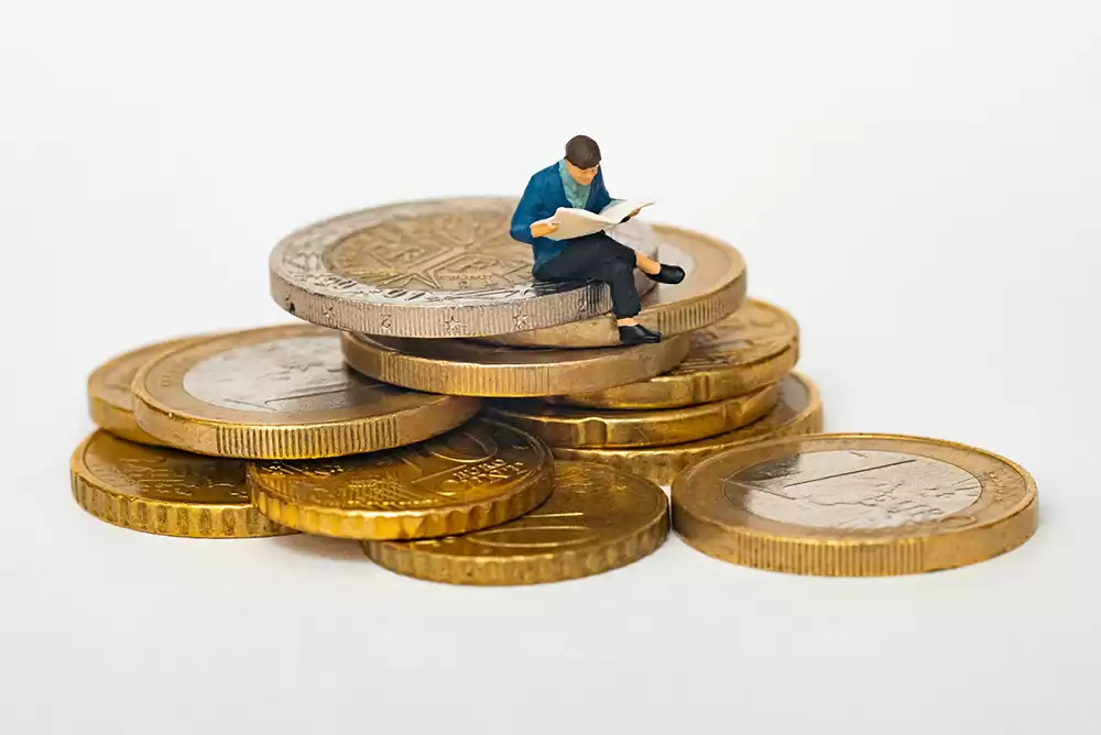 Man studying on top of coins