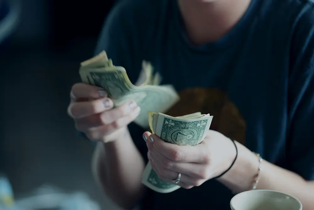 A young person counting cash