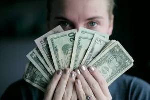 A woman holding US dollar bills.
