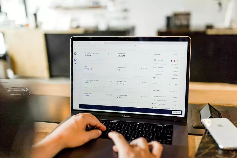 Hands on the keyboard of a laptop with a private banking portal on screen.