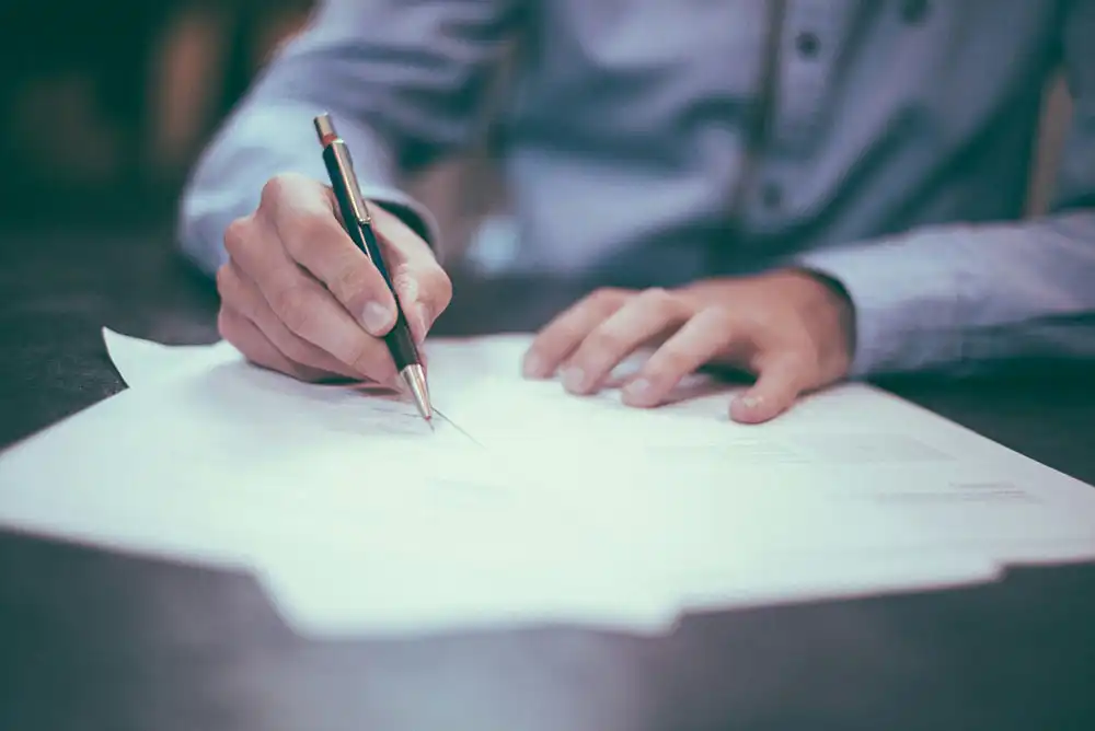 A man signing a life insurance form.