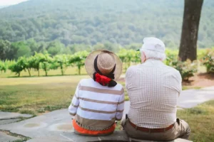 A retired couple sitting on a stone bench discussing life insurance retirement planning.